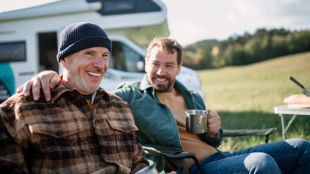 Two men on deckchairs outside motorhome - credit Getty Images